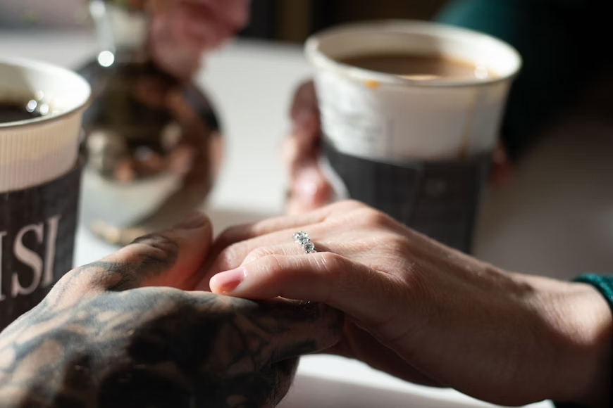 Tangan saling menggenggam di kafe